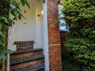 a brick house with a white door on it at 157 Watling Street South in Church Stretton