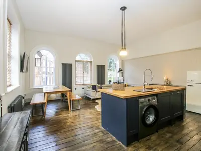 a kitchen and living room with a washing machine at 1C College Hill in Shrewsbury