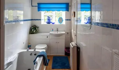 a bathroom with a tub and a sink at Ty Ffarm, Gogarth