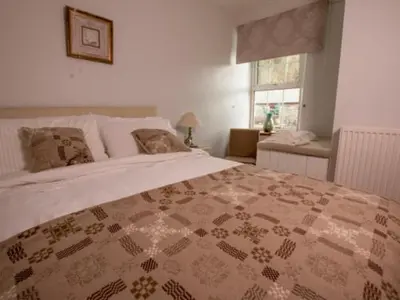 a bedroom with a large bed and a window at Ty Ffarm, Gogarth