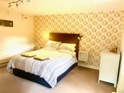 a bedroom with a large bed with a large wall at Outstanding Llangollen Riverside Apartment in Llangollen