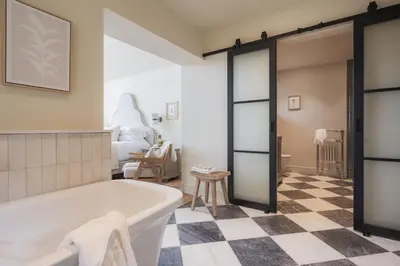 a bathroom with a tub and a checkered floor at Llys y wawr Luxury Holiday Let in Aberystwyth