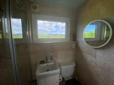 a bathroom with a toilet and a sink and a mirror at Snowdonia 1-Bed Chalet Sleeps 2 Stunning Views in Pennal