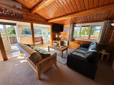 a living room with a couch and a table at Caban Enfys in Trawsfynydd