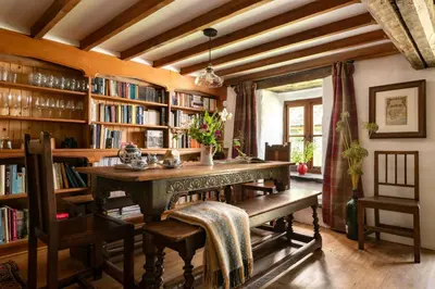 a library with a table and chairs and bookshelves at Ty Neuadd in Dolgellau
