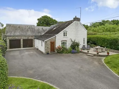 a house with a driveway and a garage at Priory cottage in Clifford
