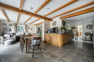 a kitchen and living room with a table and chairs at Priory cottage in Clifford