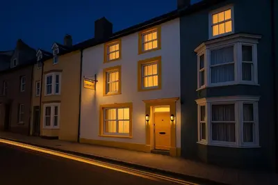 a white building with a door on a street at night at Ty Sunnymead Guesthouse in Aberystwyth