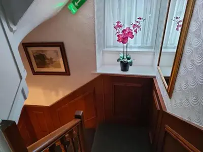 a staircase with a vase of flowers in a window at Ty Sunnymead Guesthouse in Aberystwyth