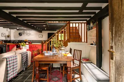a kitchen with a wooden table and chairs at Ty Trol in Dolgellau
