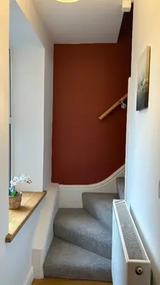 a staircase in a house with a red wall at Builth wells stay in Builth Wells