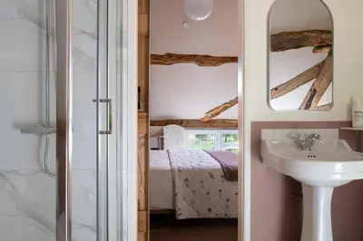 a bathroom with a sink and a mirror and a bed at Swn y Nant in Glyn-Ceiriog