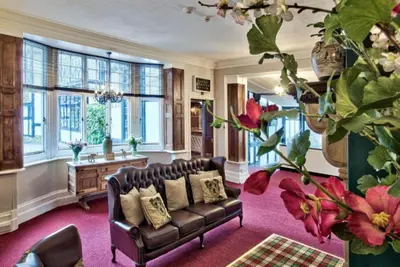 a living room with a couch and a table at Caer Beris Hotel in Builth Wells