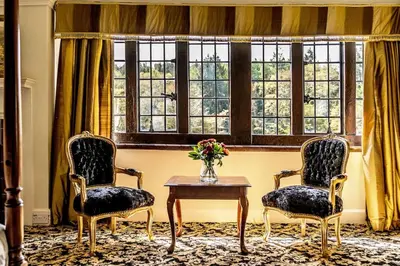 two chairs and a table in front of a window at Caer Beris Hotel in Builth Wells