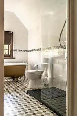 a bathroom with a tub and a toilet and a sink at Caer Beris Hotel in Builth Wells