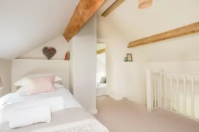 a bedroom with a white bed in a attic at Cosy cottage with stunning views, close to Ludlow in Bucknell