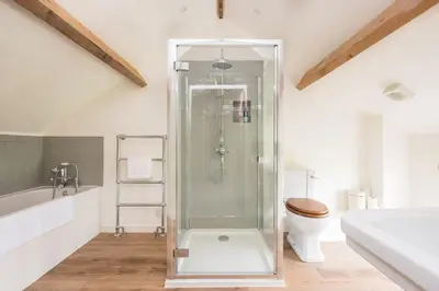 a bathroom with a shower and a toilet at Cosy cottage with stunning views, close to Ludlow in Bucknell