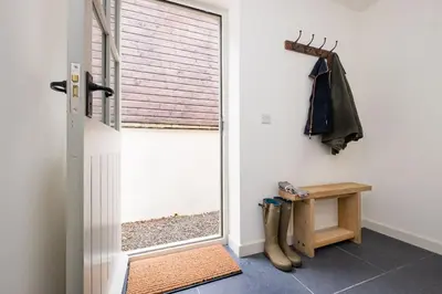 a room with a door and a bench and a window at Cosy cottage with stunning views, close to Ludlow in Bucknell