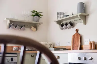 a kitchen with shelves on the wall and a counter at Cosy cottage with stunning views, close to Ludlow in Bucknell