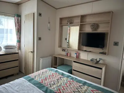 a bedroom with a bed and a desk with a television at 186 Barmouth Bay Holiday Park in Barmouth