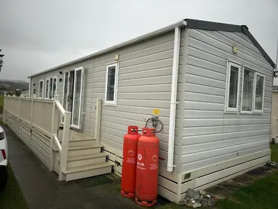 a grey house with two red fire hydrants in front of it at 186 Barmouth Bay Holiday Park in Barmouth