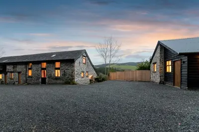 a stone house on a gravel driveway at Cae Madog Barn in Llanbrynmair