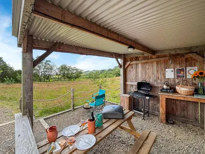 a picnic table in a shed with a view of a field at The Owl Pod - Uk50070 in Welshpool