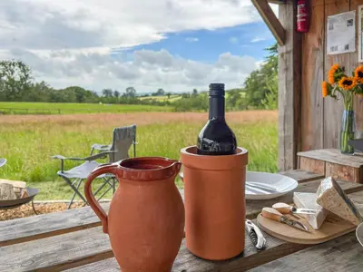 a bottle of wine sitting in a vase on a table at The Hedgehog Pod - Uk50067 in Welshpool