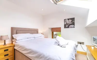 a bedroom with a large white bed and a desk at Y Pandy in Pennal
