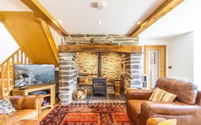 a living room with a stone fireplace at Y Pandy in Pennal