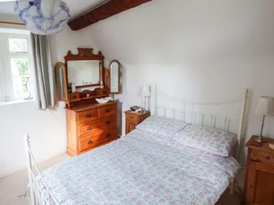 a bedroom with a bed with a mirror and a dresser at The Smithy in Leominster
