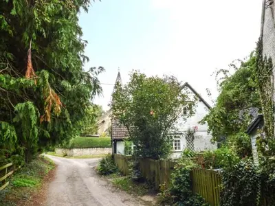 a dirt road in front of a house with a fence at The Smithy in Leominster