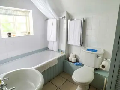 a bathroom with a tub and a toilet and a sink at The Smithy in Leominster