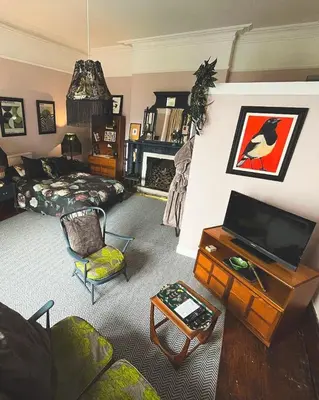 a living room with a couch a table and a tv at Bala Suite at pen Y Coed Hall in Dolgellau