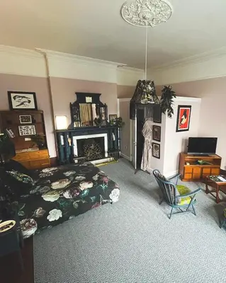a bedroom with a bed and a chair and a fireplace at Bala Suite at pen Y Coed Hall in Dolgellau