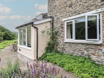 a stone house with a window and a patio at Hafod in Llangollen