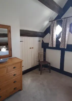 a bathroom with a wooden dresser and a mirror at The Wain House at Brinsop in Hereford