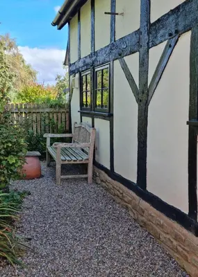 a bench sitting outside of a building with a fence at The Wain House at Brinsop in Hereford