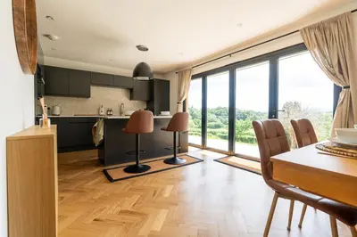 a kitchen and dining room with a table and chairs at Modern Bungalow Views of Pen y Fan in Brecon