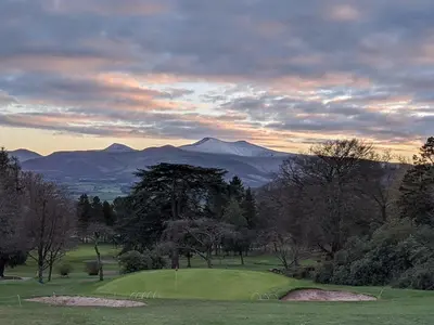 a view of a golf course with mountains in the background at Modern Bungalow Views of Pen y Fan in Brecon