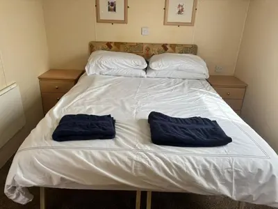 two blue towels are sitting on a bed at Cadwgan Caravan No2 in Barmouth