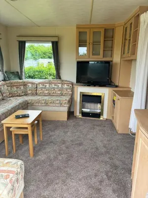 a living room with a couch and a tv at Cadwgan Caravan No2 in Barmouth