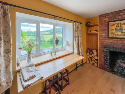 a window in a room with a table and a fireplace at Swan Cottage in Carrog