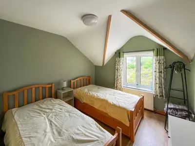 a bedroom with two beds and a window at Swan Cottage in Carrog