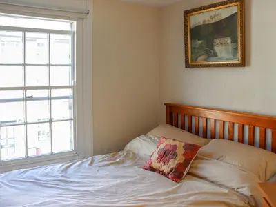a bedroom with a bed with a pillow on it at Crescent Cottage in Newtown