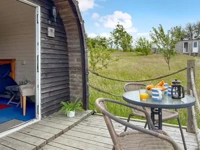 a patio with a table and chairs on a porch at The Sheep Pod - Uk50074 in Welshpool