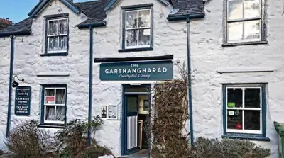 a white building with a sign in front of it at CABIN 8 Pet friendly Family glamping Seaview in Llwyngwril