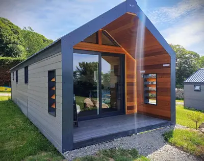 a tiny house with a large glass door at CABIN 8 Pet friendly Family glamping Seaview in Llwyngwril