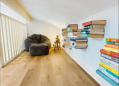 a room with a stack of books on the wall at Honey Bee Cottage Tiny House Welshpool in Welshpool
