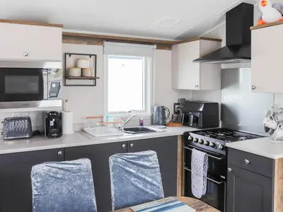 a kitchen with a sink and a stove top oven at The Laughing Seagull - Uk50213 in Aberystwyth